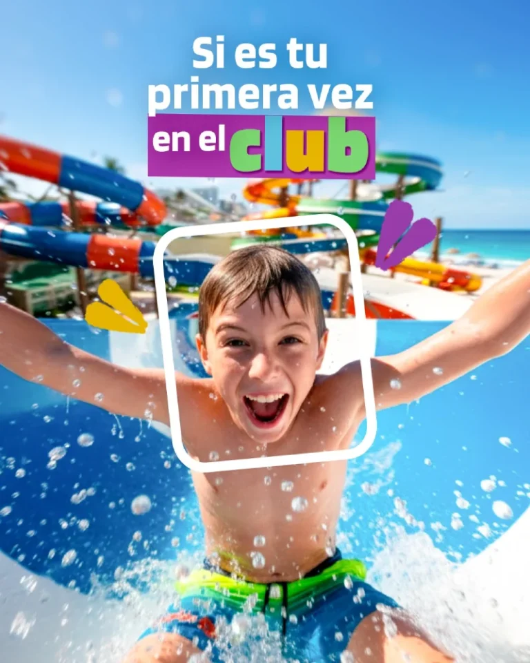 Boy sliding down water slide at water park under clear sky.